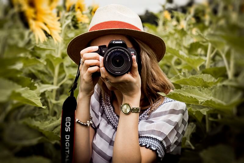 Girl taking photograph using a DSLR camera