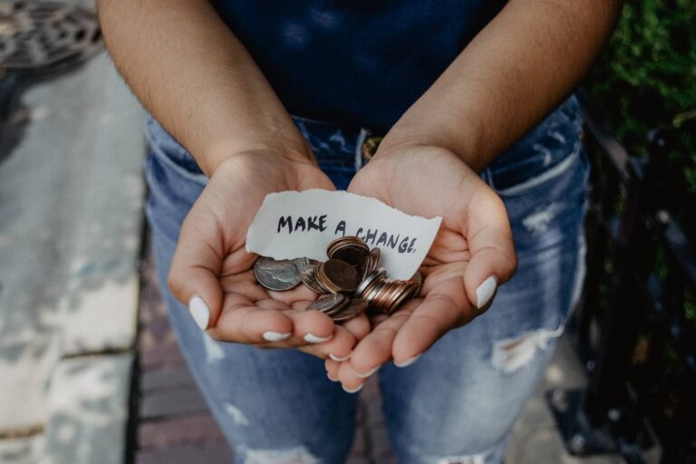 A woman holding money on her hands with a text 'Make a Change' on paper